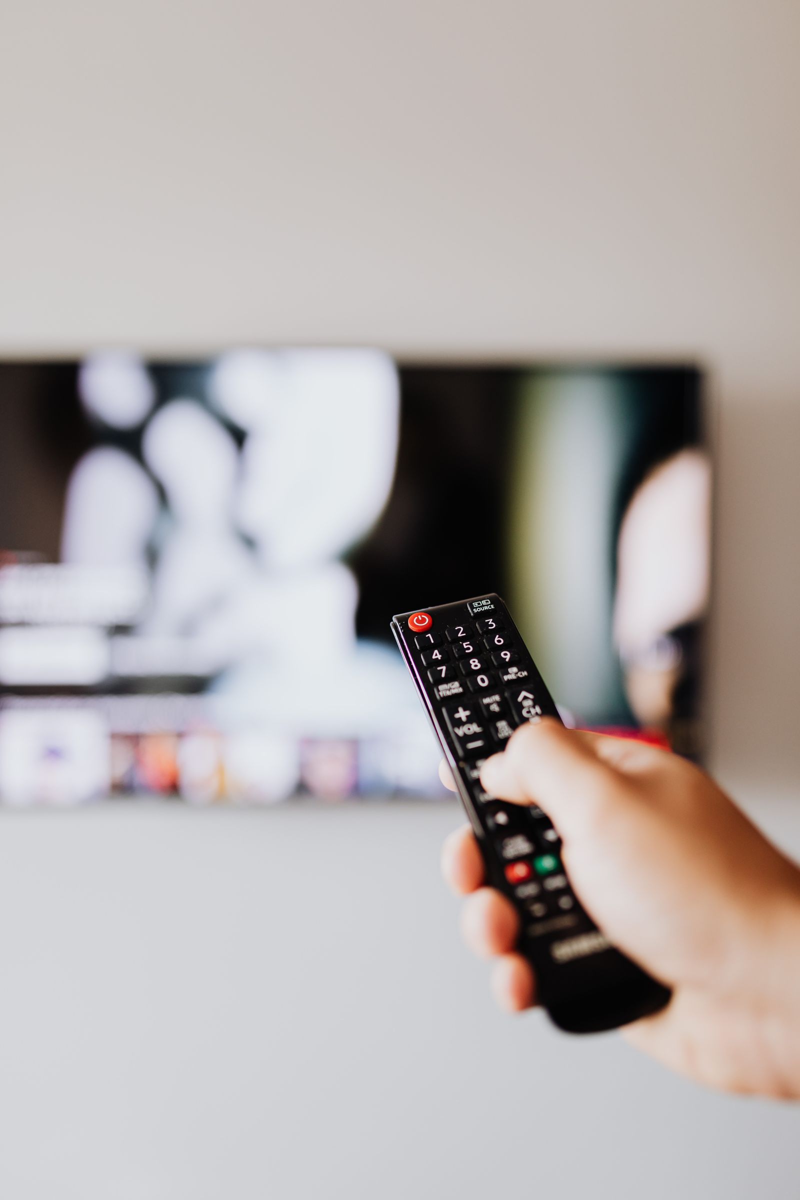 Fjärrkontroll riktad mot en smart tv som visar startsidan för en iptv-app