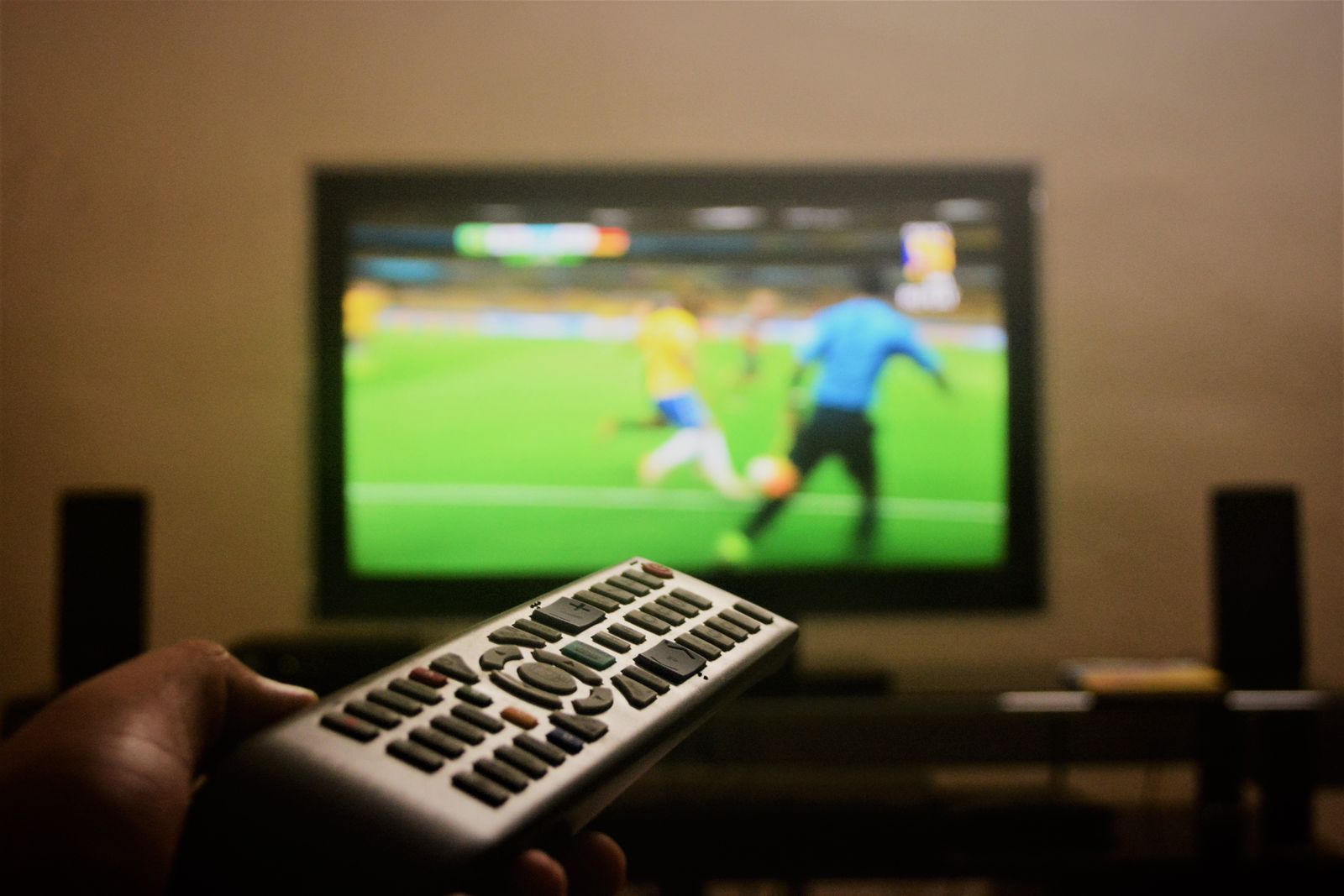 Smart tv som visar sport i skarp bild med en iptv-fjärrkontroll i förgrunden