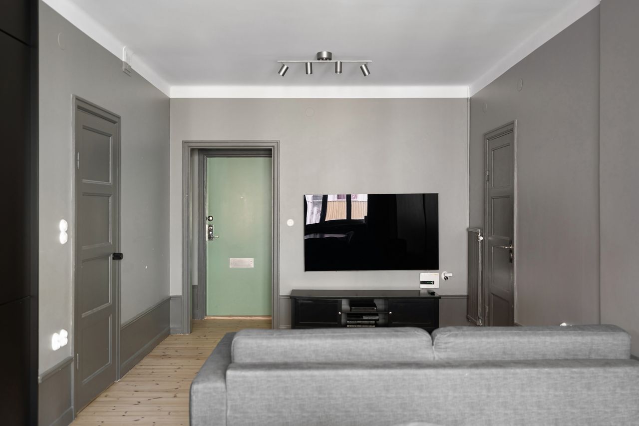 minimalistiskt vardagsrum med väggmonterad smart-tv