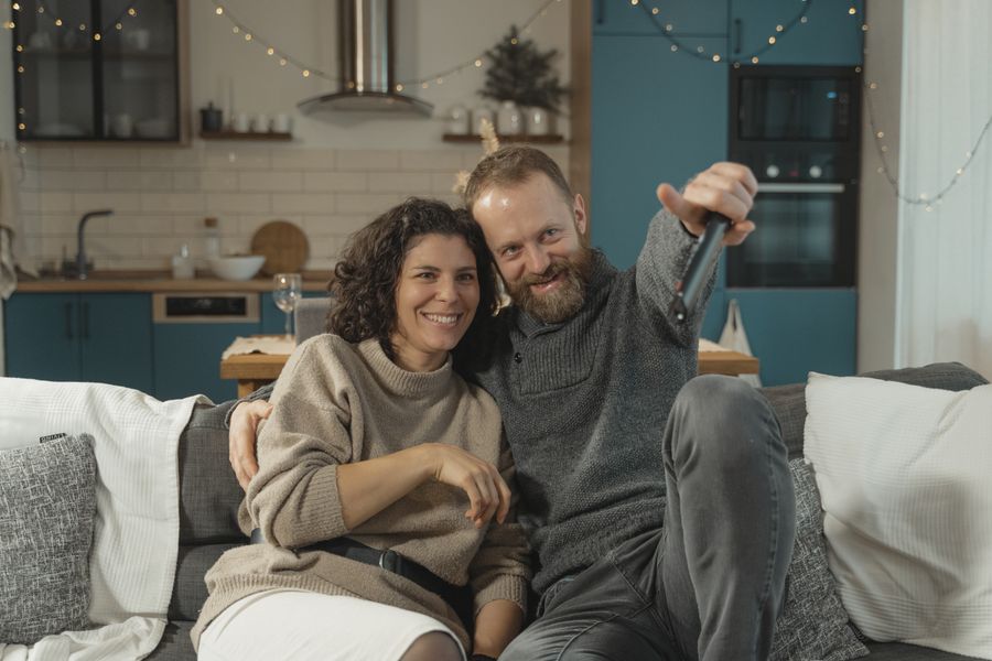 nordiskt par som tittar på iptv hemma i vardagsrummet