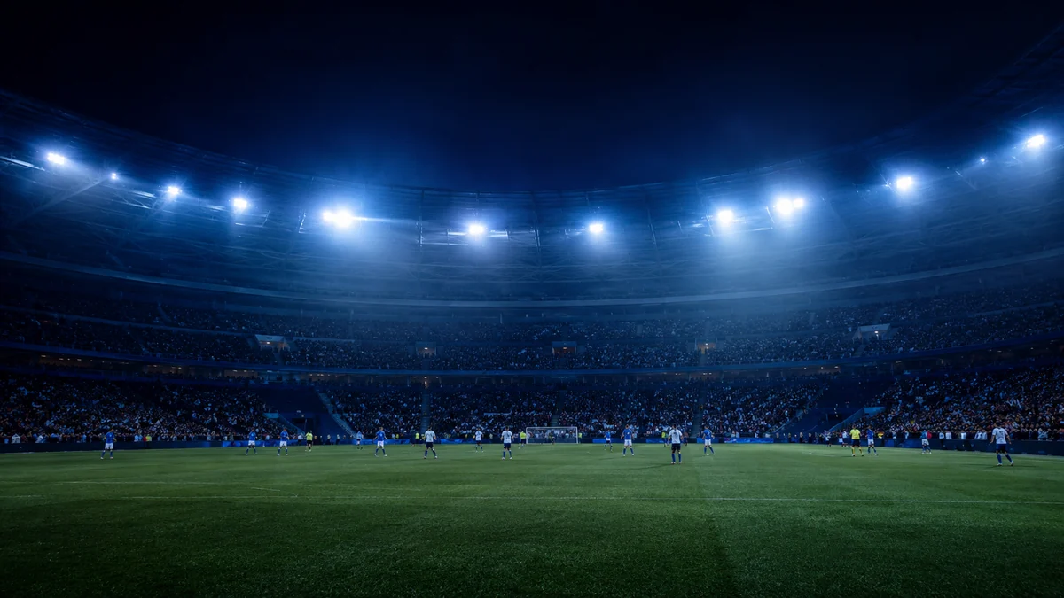 Fotbollsmatch under strålkastare på en fullsatt arena